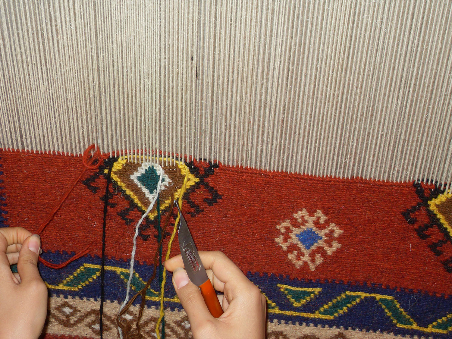 Qaschqai-Knüpferinnen an einem Bodenwebstuhl bei Firuzabad, Iran